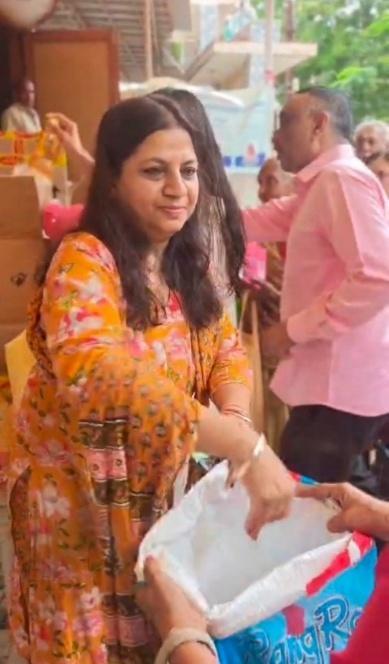 Handing over essential grocery and ghee kits to a beneficiary